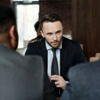 Business professionals in suits having a focused meeting indoors.
